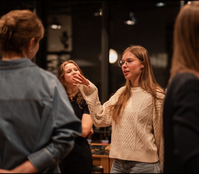 A female mentor explaining her role at Vinted to a group of students
